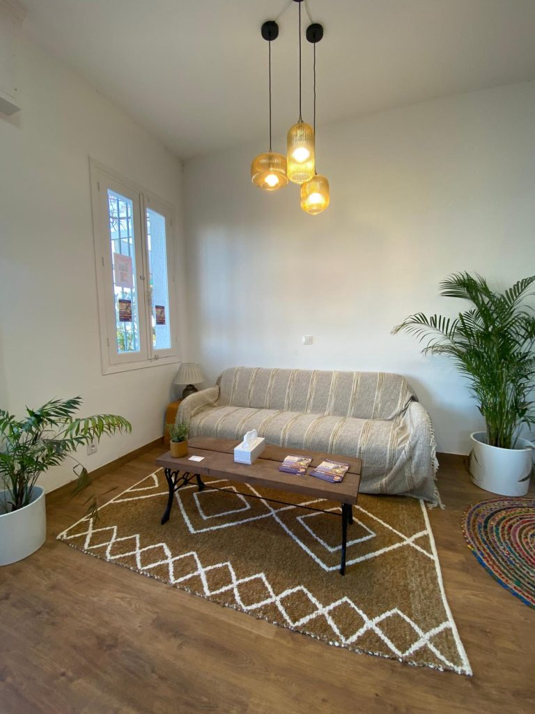 A long sofa with recycled table and pendant lighting make a welcoming waiting area or an inside place for coffee
