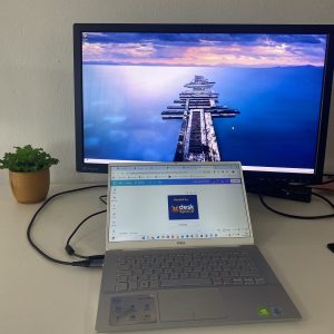 A laptop in the foreground and an external monitor with a different image in the background. DeskSpace shows you how to set it up.