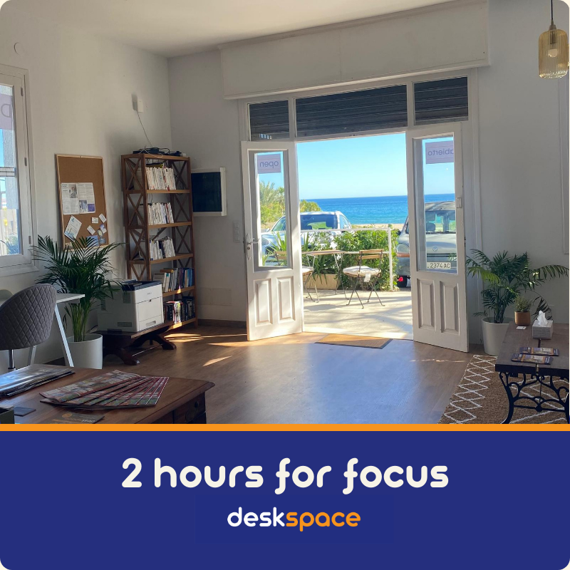 A picture taken from within DeskSpace Coworking Mojacar, Spain showing the sea view, bookshelf to the left and a printer.
